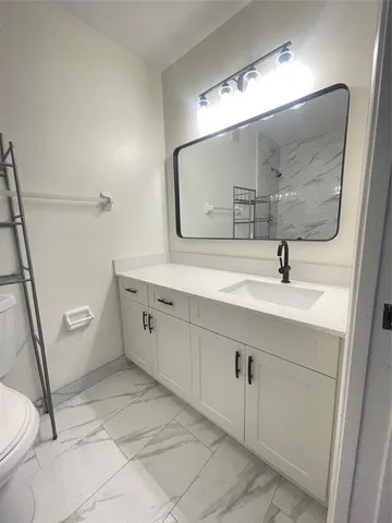 a bathroom with a sink a toilet and mirror