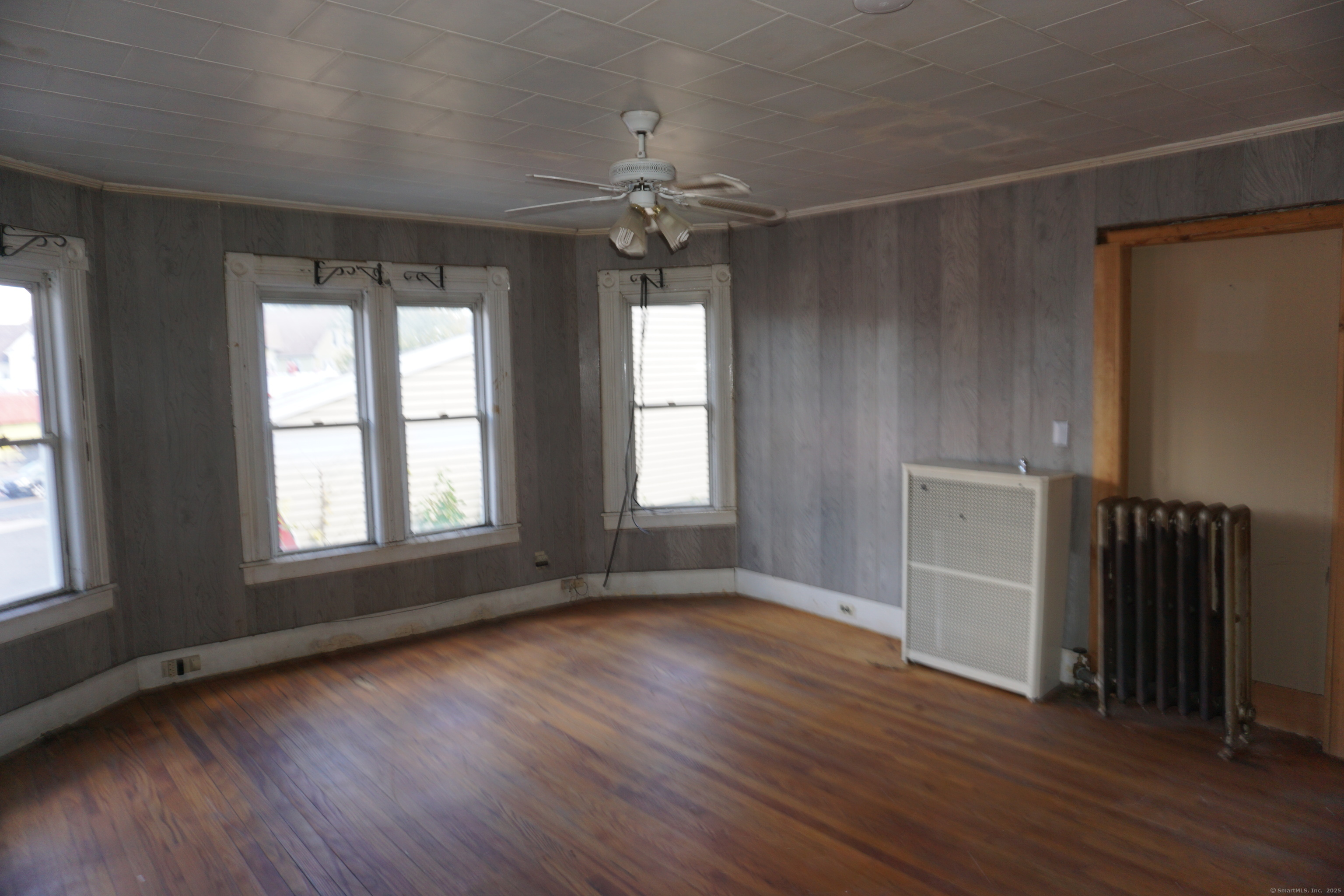 327 Orange Street Springfield, MA 01108 - Photo 11 of 32 an empty room with wooden floor cabinet and windows