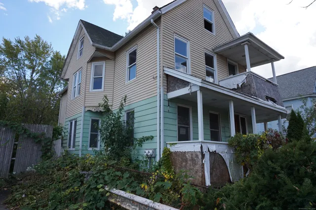 a view of a white house next to a yard