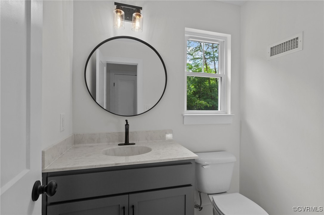 726 Stoney Point Road Cumberland, VA 23040 - Photo 13 of 32 a bathroom with a toilet a sink and mirror