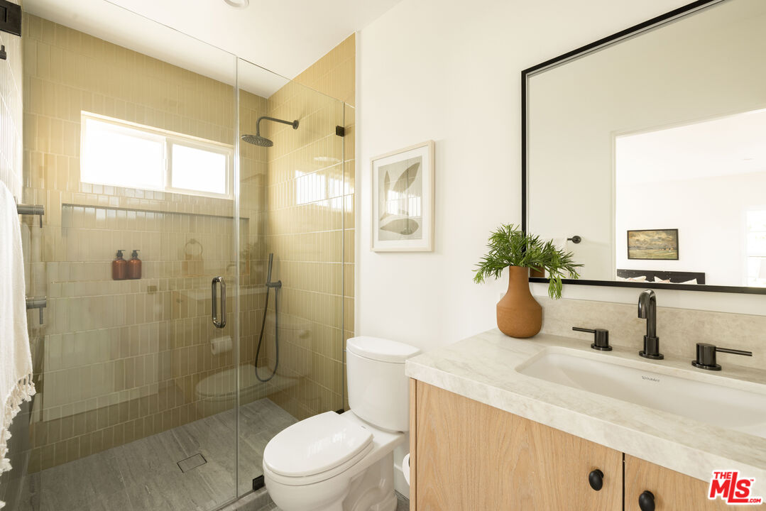 1016 Manzanita Street Los Angeles, CA 90029 - Photo 14 of 35 a bathroom with a granite countertop sink a toilet and shower