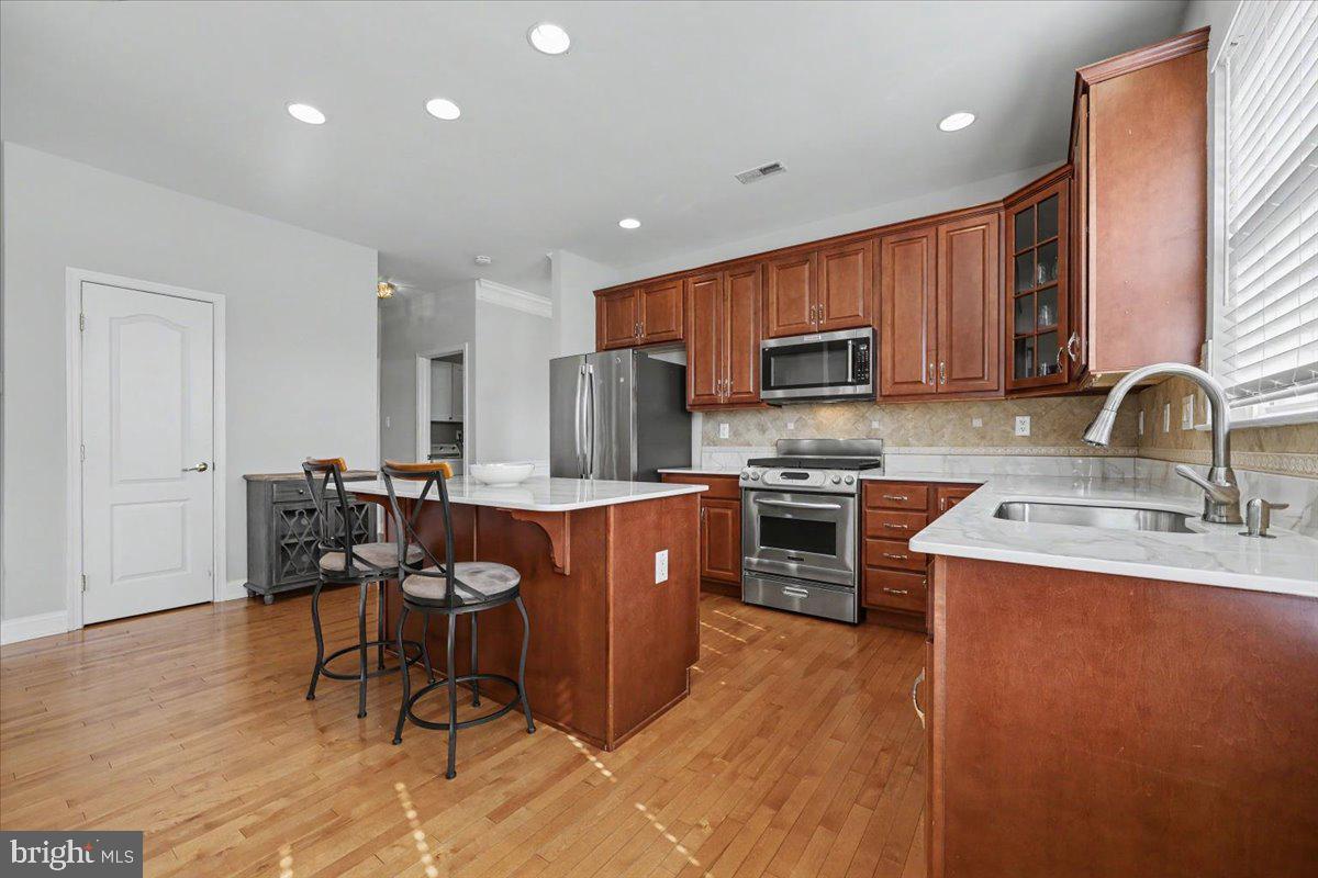 32 Par Circle Pottstown, PA 19464 - Photo 11 of 34 a kitchen with stainless steel appliances granite countertop a sink dishwasher a stove a refrigerator with a dining table and chairs