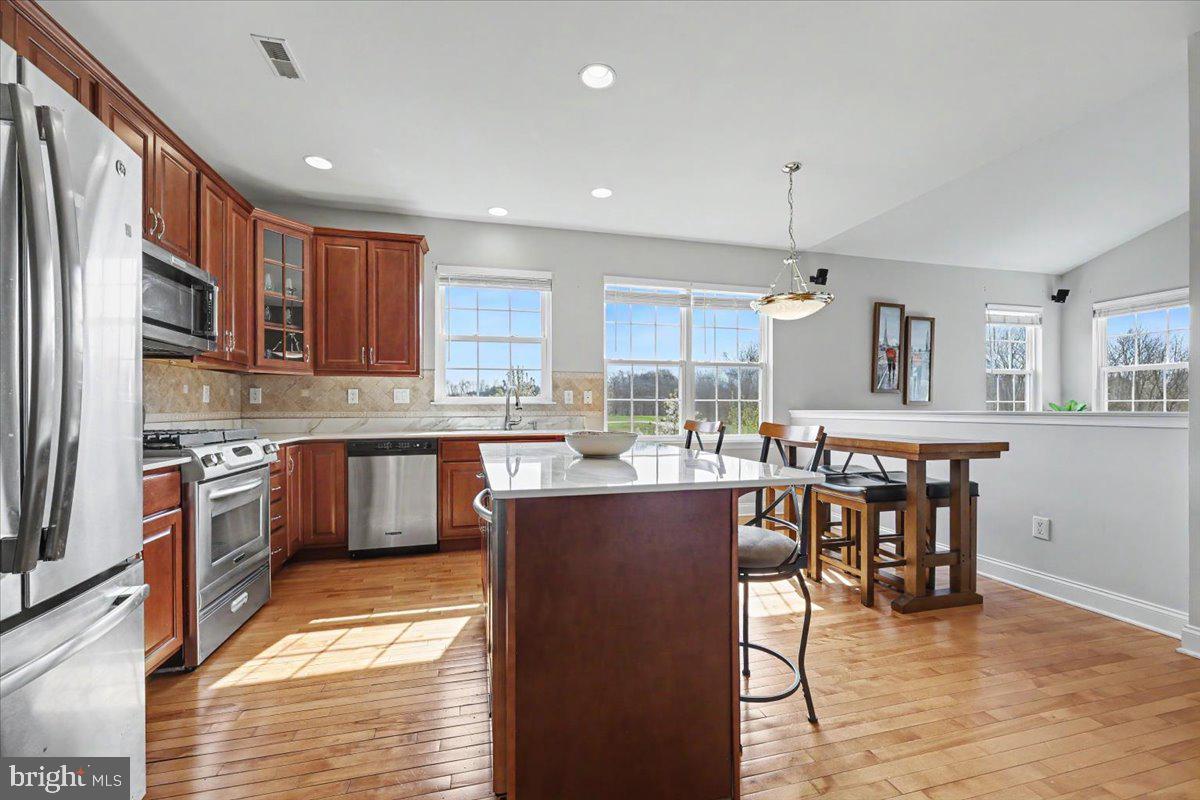 32 Par Circle Pottstown, PA 19464 - Photo 8 of 34 a kitchen with stainless steel appliances granite countertop a stove top oven a sink dishwasher a dining table and chairs with wooden floor