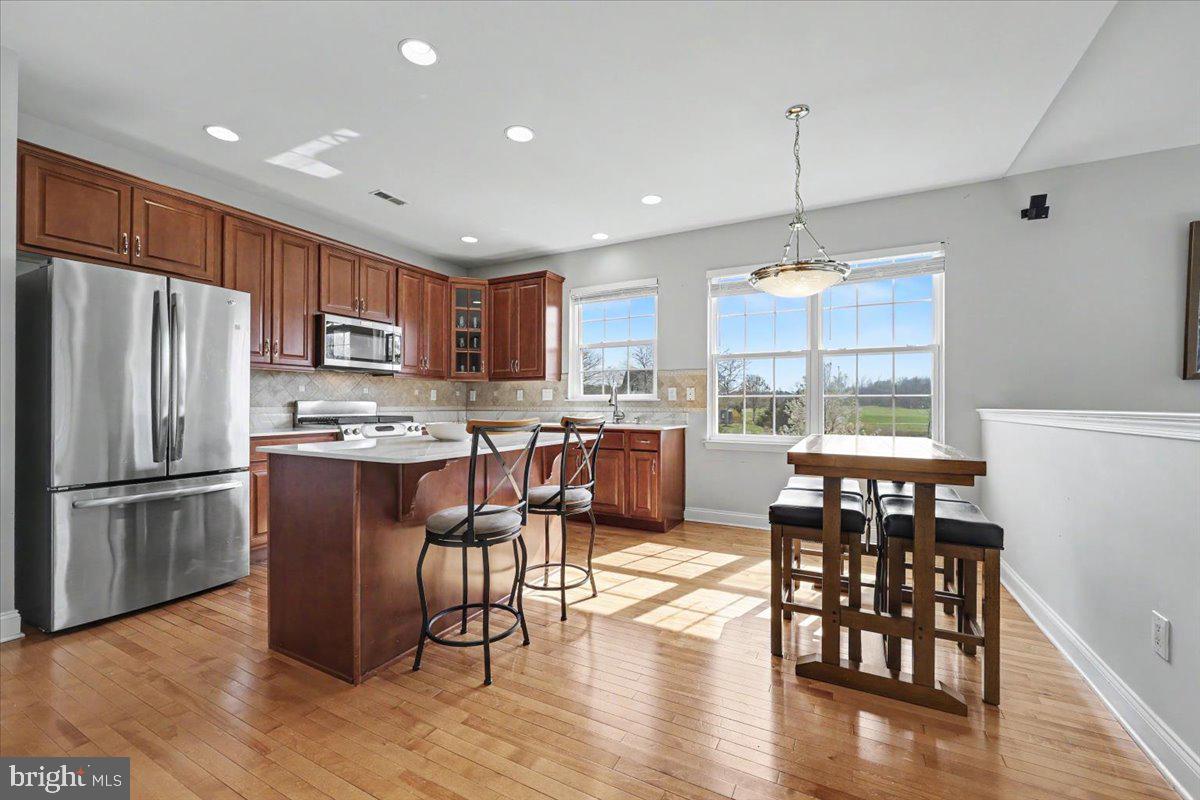 32 Par Circle Pottstown, PA 19464 - Photo 9 of 34 a kitchen with stainless steel appliances granite countertop a refrigerator a stove top oven a sink dishwasher and a dining table with wooden floor