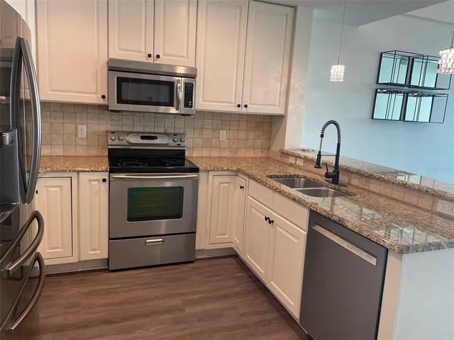 a kitchen with granite countertop a stove top oven and sink