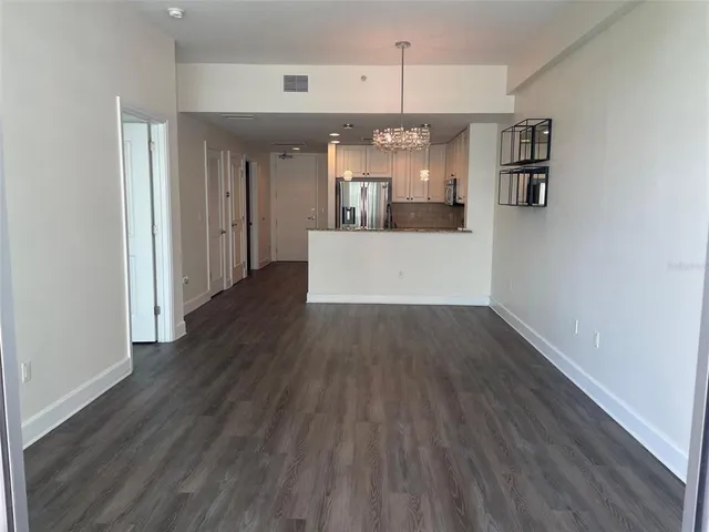 a view of a living room and kitchen with wooden floor