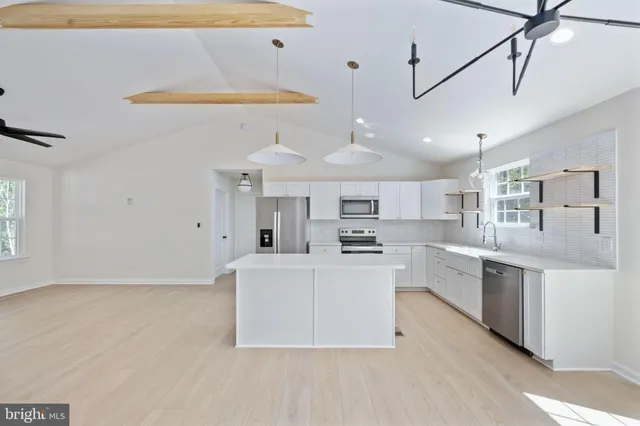 a view of empty room with window and wooden floor