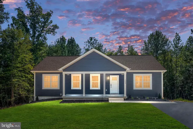 a front view of a house with a yard and green space