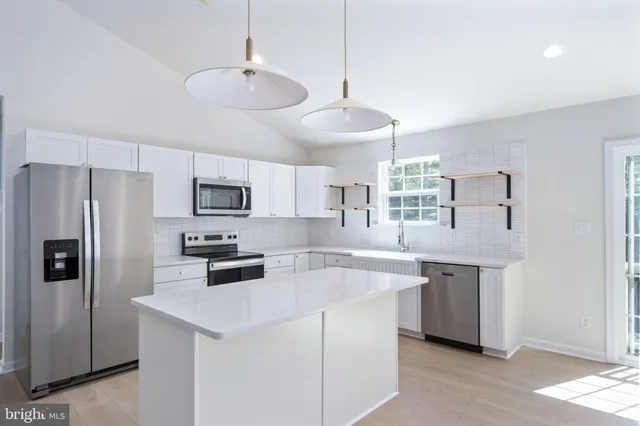 a view of kitchen with refrigerator stove microwave and cabinets