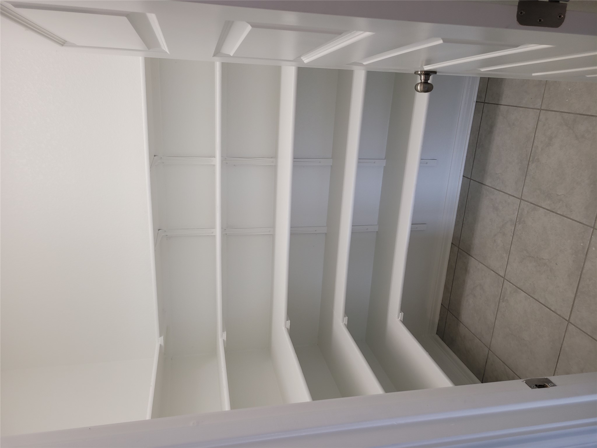 131 Wild Wind Cove Jarrell, TX 76537 - Photo 13 of 26 Spacious pantry featuring multiple white shelving units and gray tile flooring