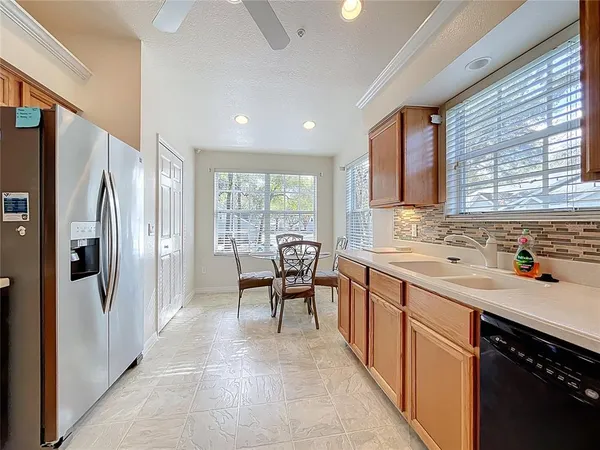 a kitchen with stainless steel appliances granite countertop sink refrigerator and dining table