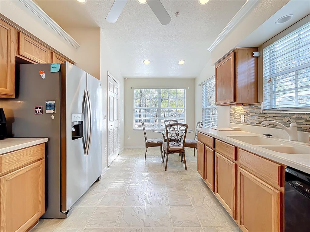 1050 Loch Vail, Unit 21 Apopka, FL 32712 - Photo 16 of 46 a kitchen with stainless steel appliances granite countertop sink refrigerator and dining table