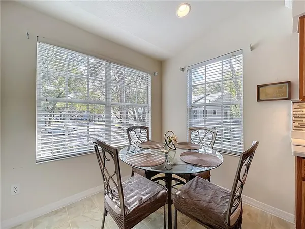a kitchen with stainless steel appliances kitchen island granite countertop a sink a stove a kitchen island and chairs