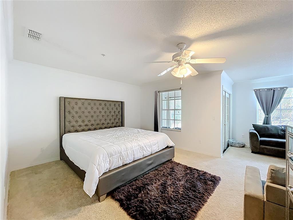 1050 Loch Vail, Unit 21 Apopka, FL 32712 - Photo 24 of 46 a bedroom with a large bed and a couch