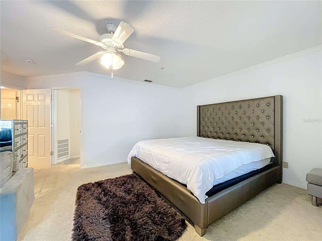 1050 Loch Vail, Unit 21 Apopka, FL 32712 - Photo 25 of 46 a bedroom with a large bed and a chandelier