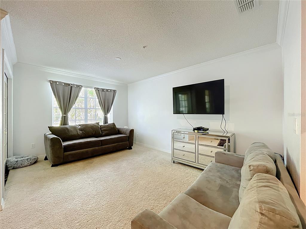1050 Loch Vail, Unit 21 Apopka, FL 32712 - Photo 28 of 46 a living room with furniture and a flat screen tv