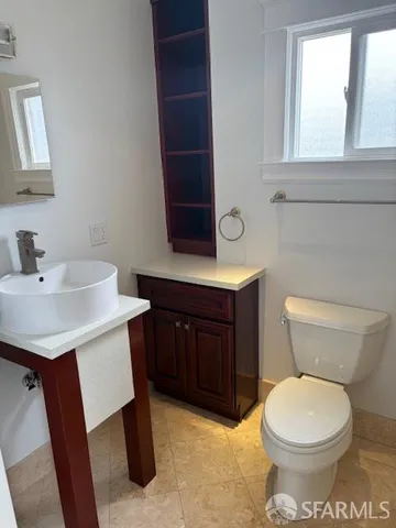 a bathroom with a toilet a sink and a window