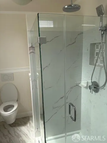 a bathroom with a toilet and a shower