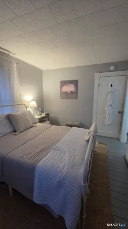 a bedroom with a bed and a painting on the wall