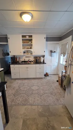 a kitchen with granite countertop a stove a sink and a refrigerator