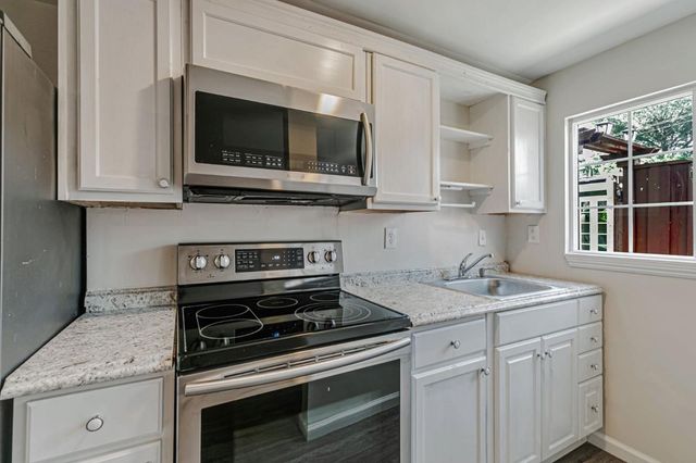 a kitchen with stainless steel appliances granite countertop a sink stove and microwave