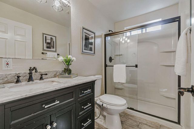 a bathroom with a granite countertop shower and a sink