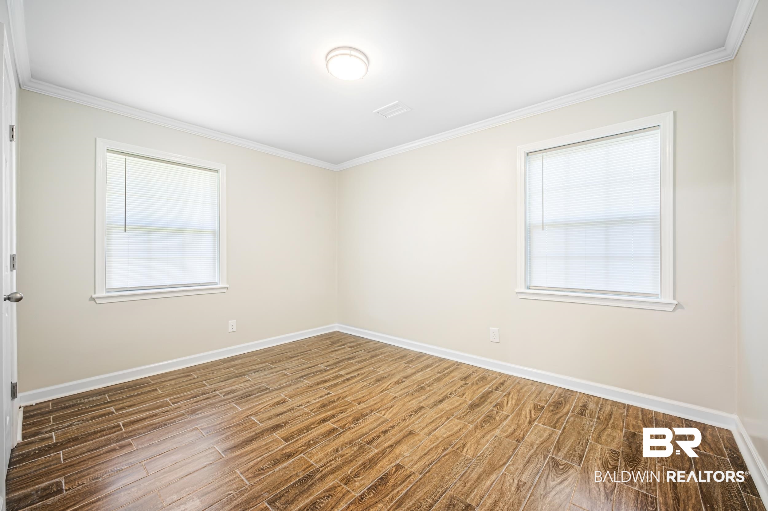1605 Collier Avenue Bay Minette, AL 36507 - Photo 26 of 36 Spare room with wood finish floors, ornamental molding, and healthy amount of natural light