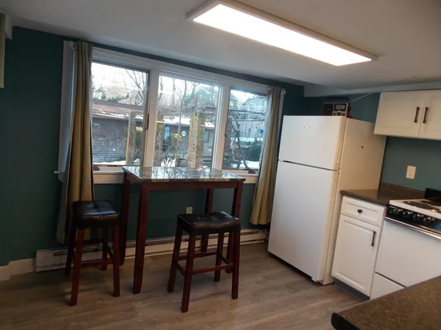 a kitchen with refrigerator a table and chairs