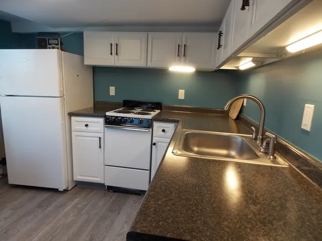 a kitchen with granite countertop a sink stainless steel appliances and cabinets