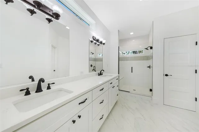 a bathroom with a double vanity sink mirror and shower