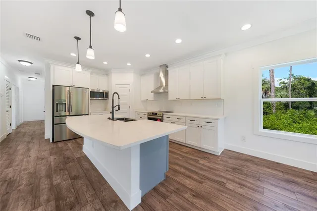 a kitchen with a sink a window stainless steel appliances and cabinets