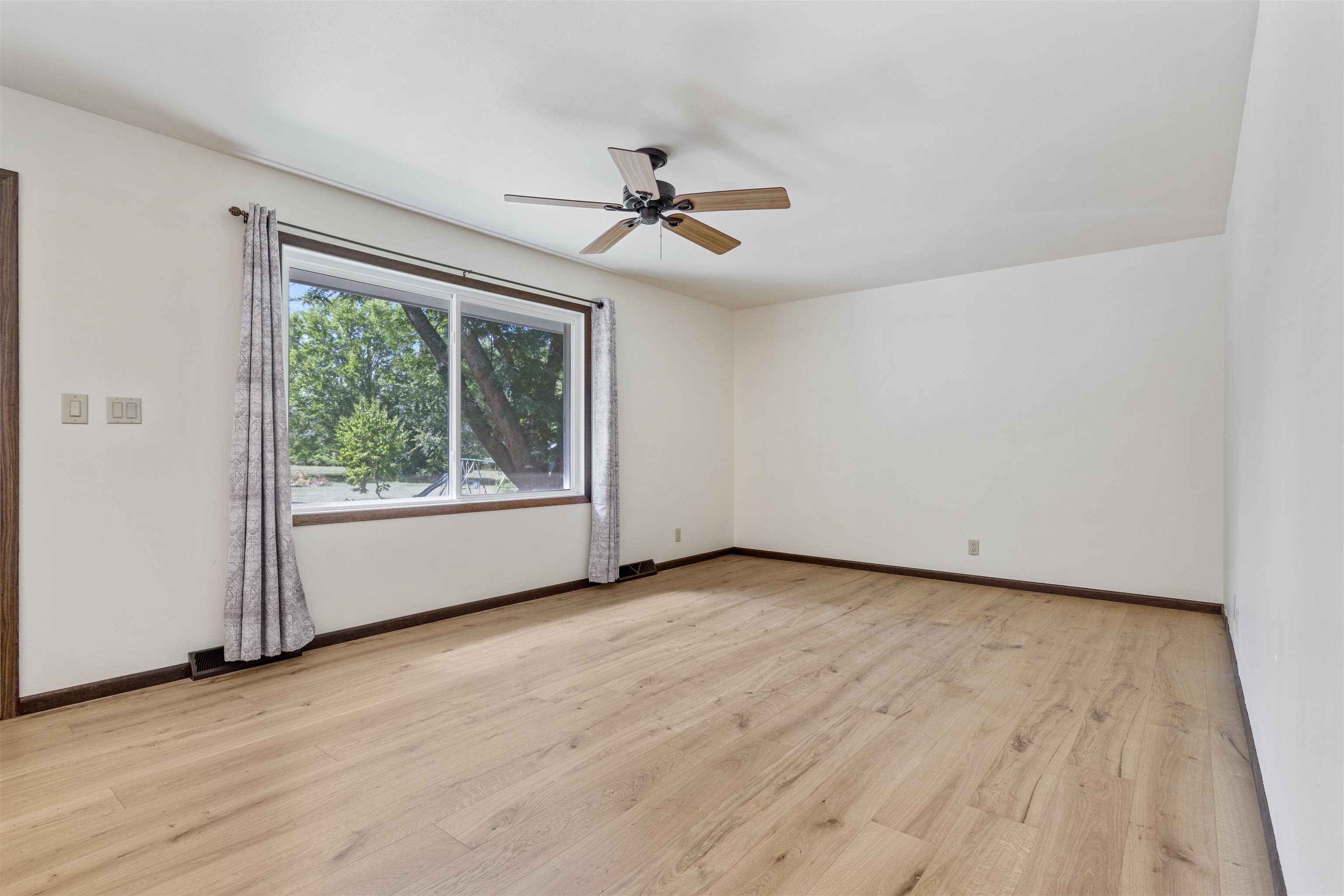 7660 Stephens Road Rockton, IL 61072 - Photo 11 of 34 an empty room with wooden floor chandelier fan and windows