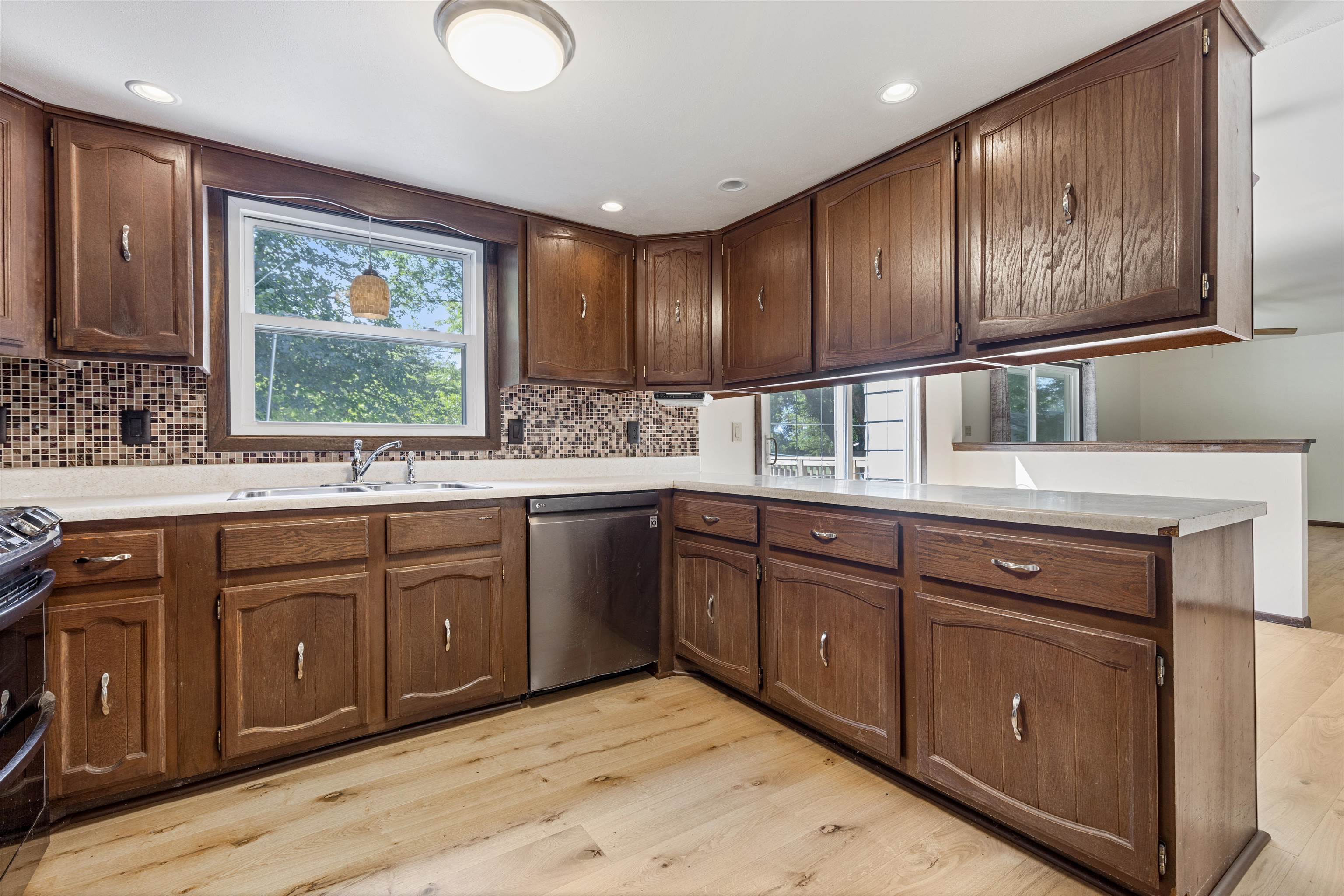 7660 Stephens Road Rockton, IL 61072 - Photo 8 of 34 a kitchen with stainless steel appliances granite countertop wooden cabinets a stove and a large window