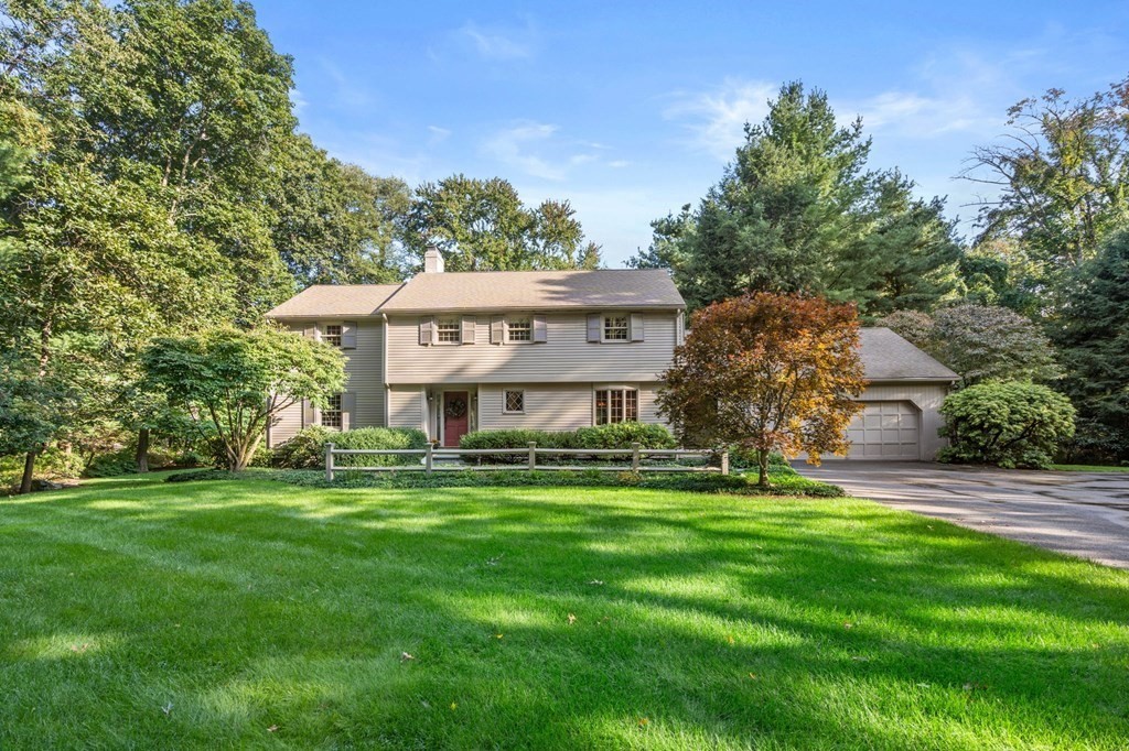 a view of a house with a big yard and large trees