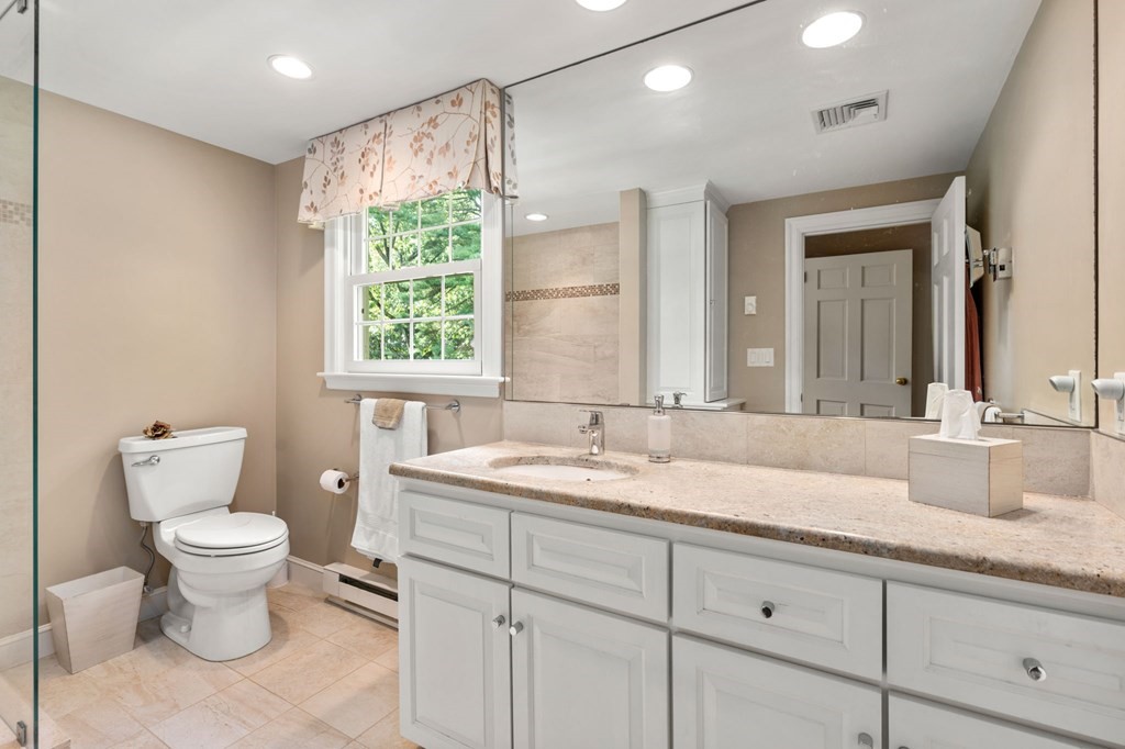 17 Fields Pond Road Weston, MA 02493 - Photo 27 of 41 a bathroom with a granite countertop sink a toilet and a mirror