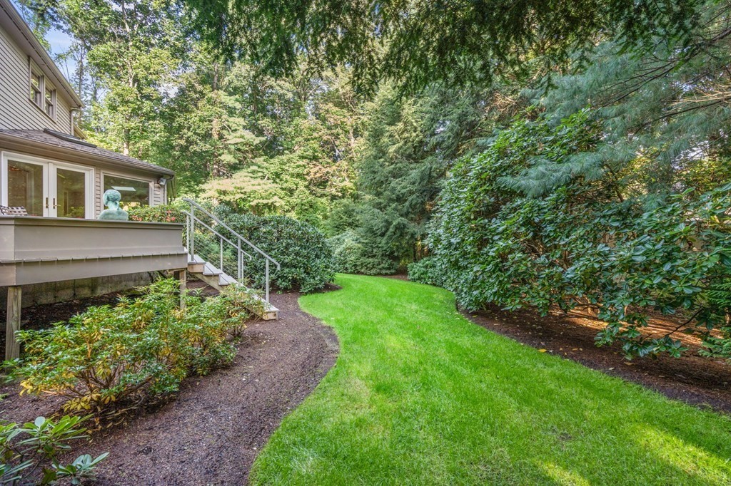 17 Fields Pond Road Weston, MA 02493 - Photo 33 of 41 a view of a yard in front of a house with plants and large trees