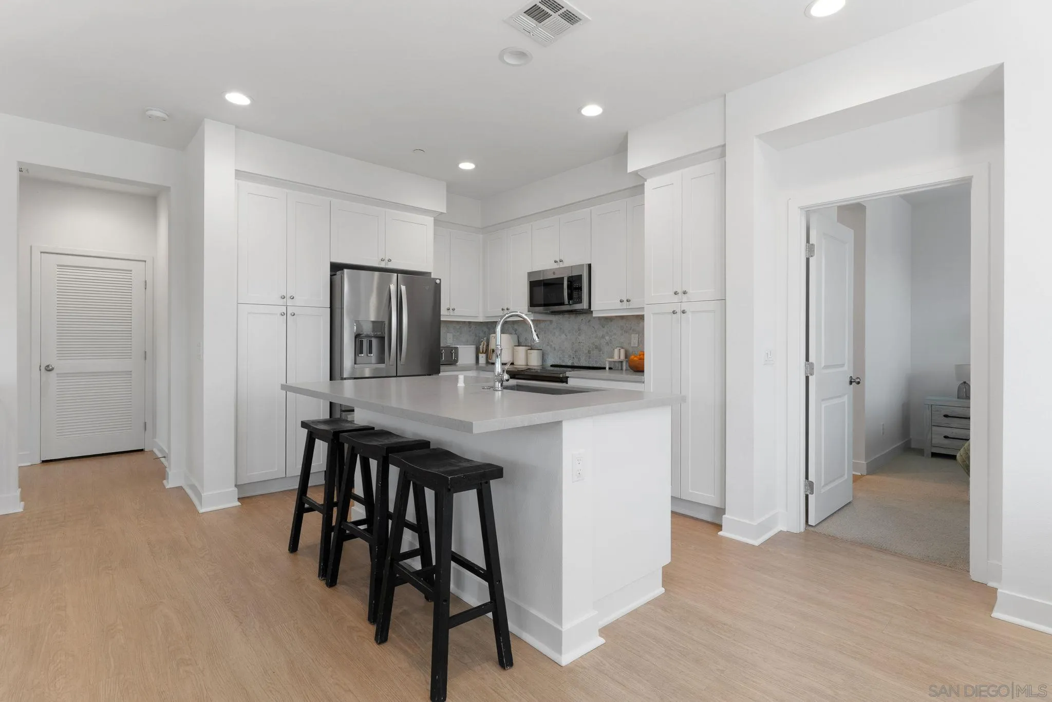 8702 Barbados Lane Santee, CA 92071 - Photo 16 of 39 a kitchen with kitchen island appliances cabinets and furniture
