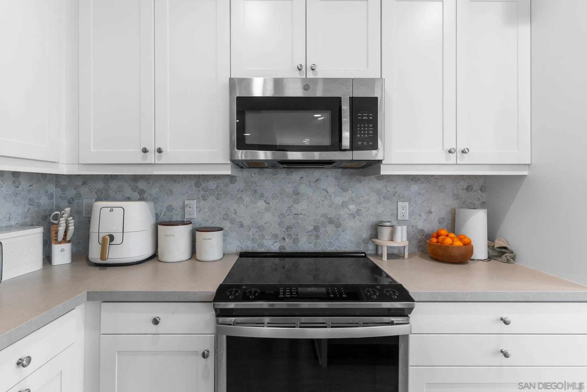 8702 Barbados Lane Santee, CA 92071 - Photo 19 of 39 a kitchen with a stove and white cabinets