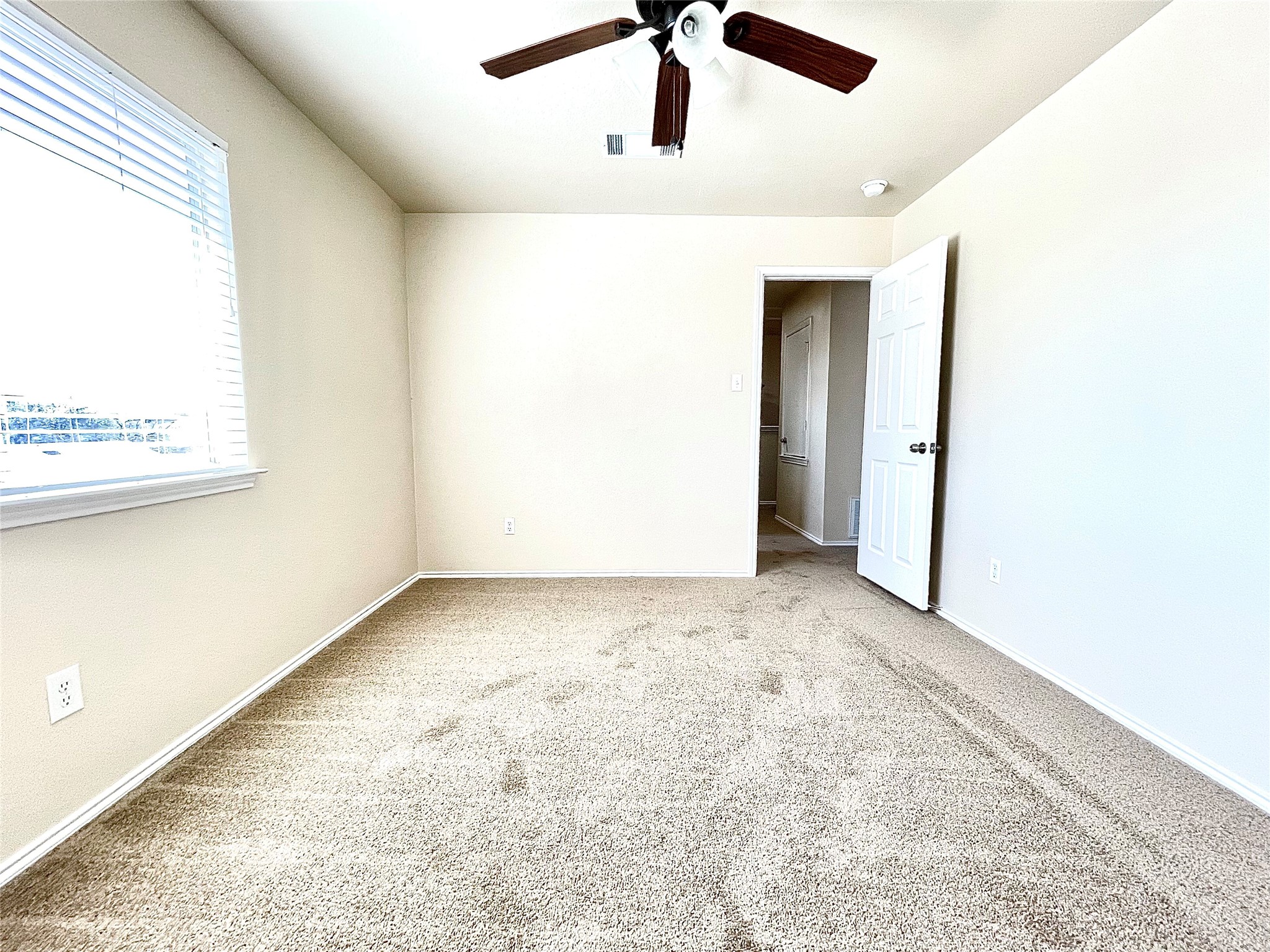 508 Emma Rose Trail Leander, TX 78641 - Photo 23 of 40 A well-lit bedroom features plush carpeting and a ceiling fan, offering a comfortable retreat.