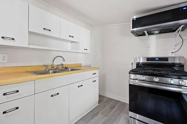 a kitchen with a sink a stove and cabinets