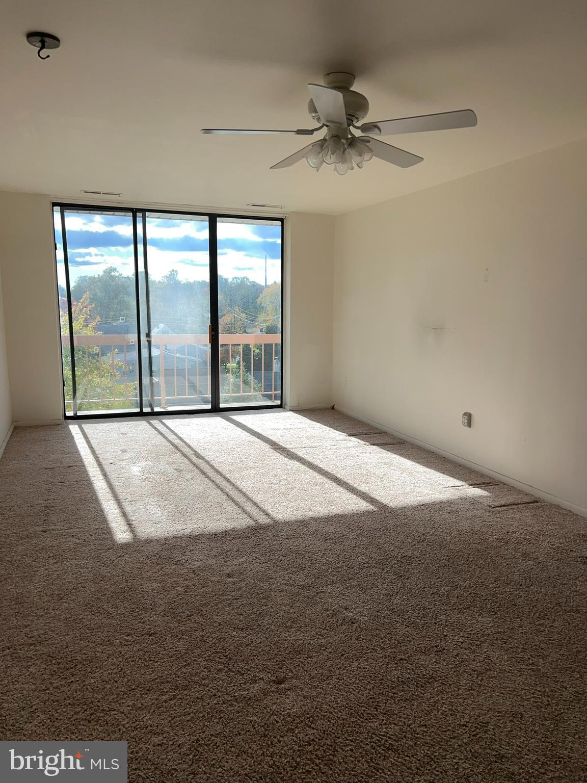 130 Slade Avenue, Unit 406 Baltimore, MD 21208 - Photo 5 of 11 a view of a livingroom with a ceiling fan and window