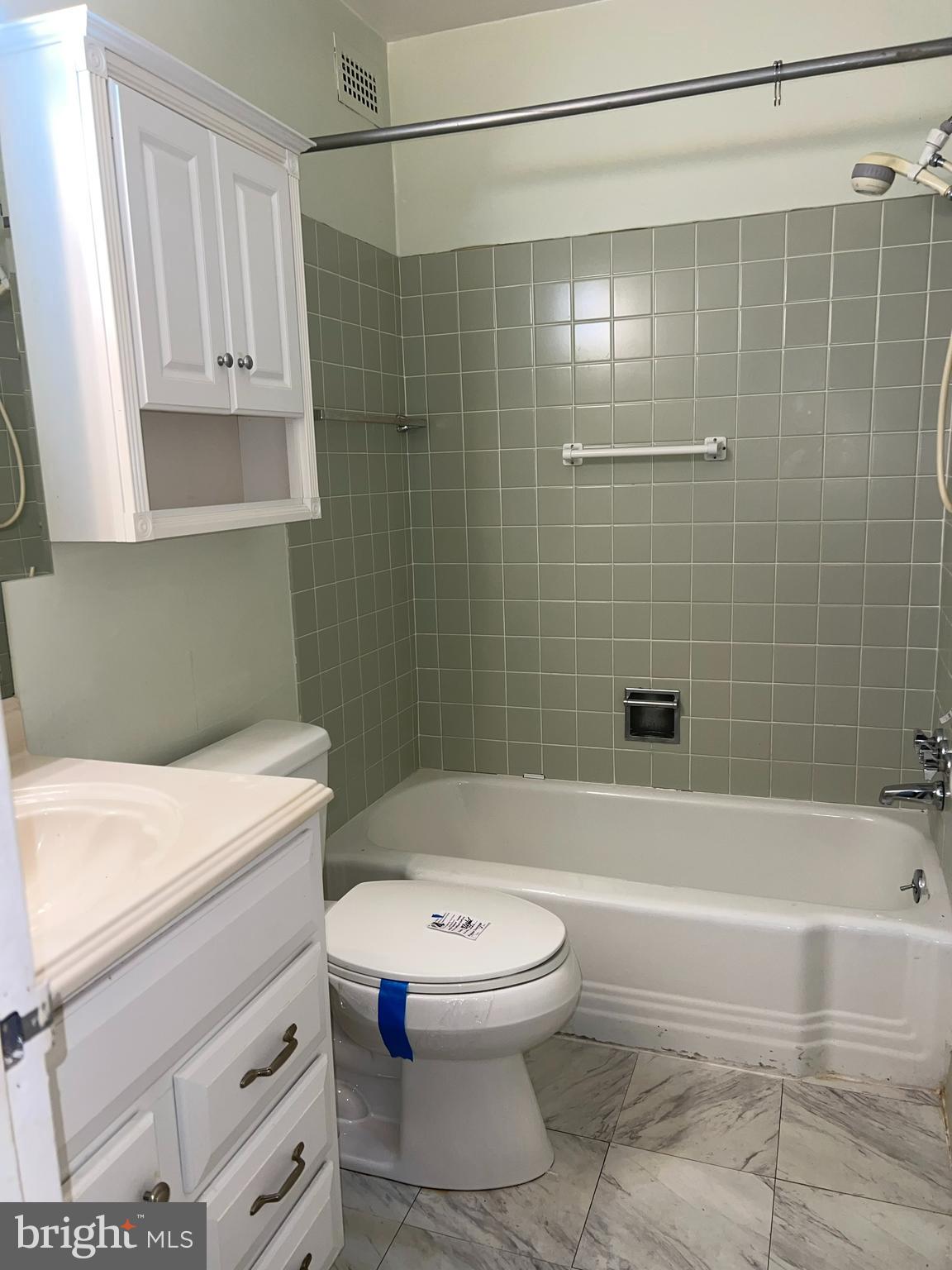 130 Slade Avenue, Unit 406 Baltimore, MD 21208 - Photo 8 of 11 a bathroom with a sink a toilet and shower