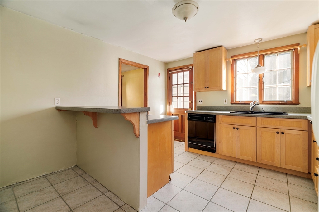 97 MacArthur Road Stoneham, MA 02180 - Photo 13 of 30 a kitchen with granite countertop a stove a sink and a refrigerator