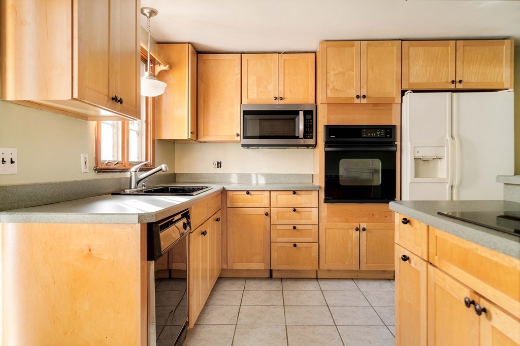97 MacArthur Road Stoneham, MA 02180 - Photo 14 of 30 a kitchen with stainless steel appliances granite countertop a sink a stove and a refrigerator
