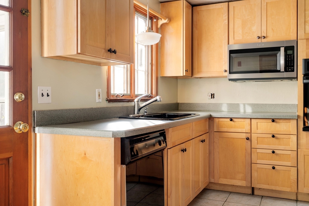 97 MacArthur Road Stoneham, MA 02180 - Photo 15 of 30 a kitchen with stainless steel appliances granite countertop a sink and a microwave