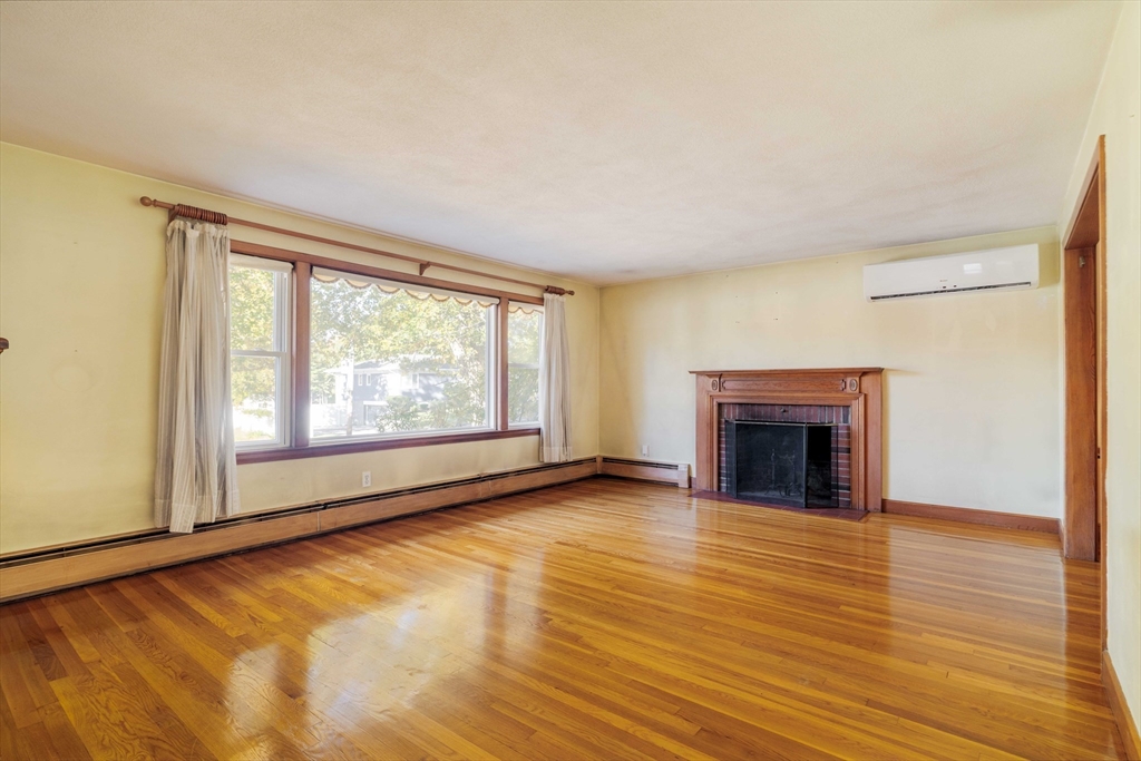 97 MacArthur Road Stoneham, MA 02180 - Photo 6 of 30 a view of empty room with wooden floor and fireplace