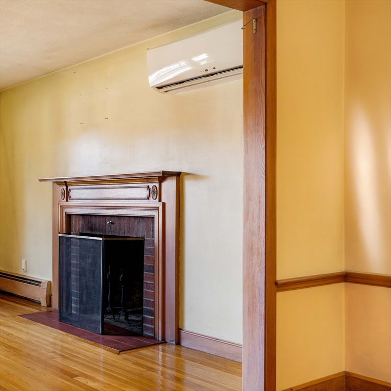 97 MacArthur Road Stoneham, MA 02180 - Photo 8 of 30 a view of an empty room with wooden floor and a fireplace