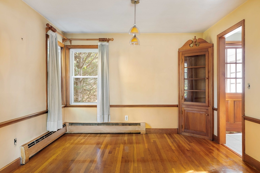 97 MacArthur Road Stoneham, MA 02180 - Photo 10 of 30 a view of an empty room with a window and wooden floor