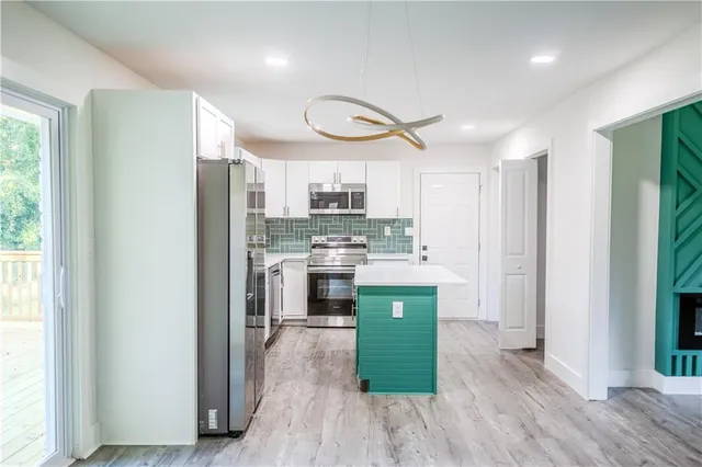 a kitchen with a refrigerator a sink and a stove top oven