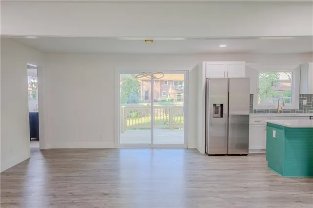 a view of kitchen with refrigerator and wooden floor